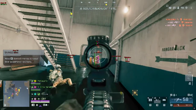 Battlefield 6 red-dot sight aimed along a hangar deck corridor marked with stencil signage.